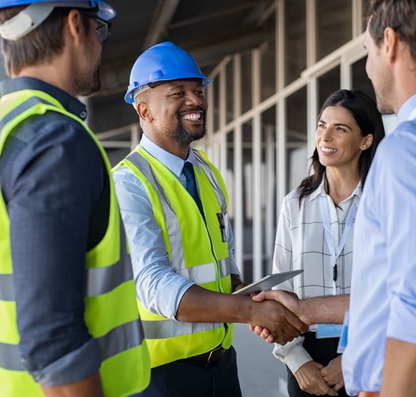 Engineer wearing safety hat handshaking a client