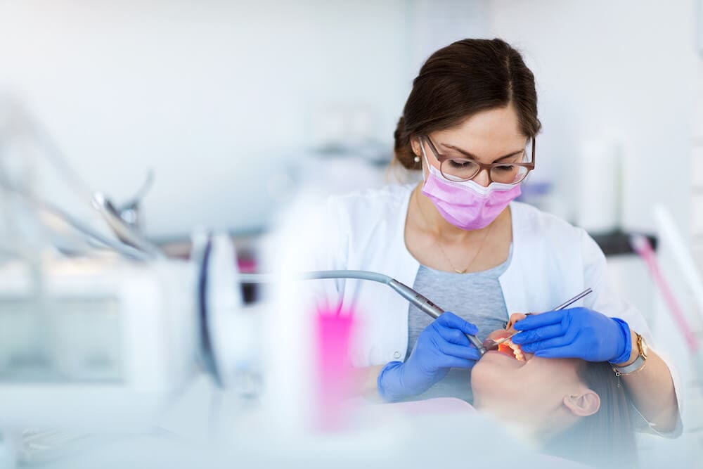 dentist performing a teeth cleaning procedure